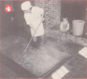 worker mixing ingredients in a trough