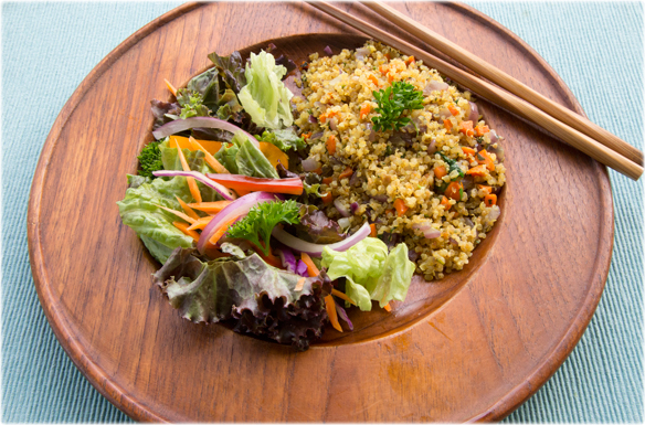 quinoa and a green salad on a wooden plate with chopsticks